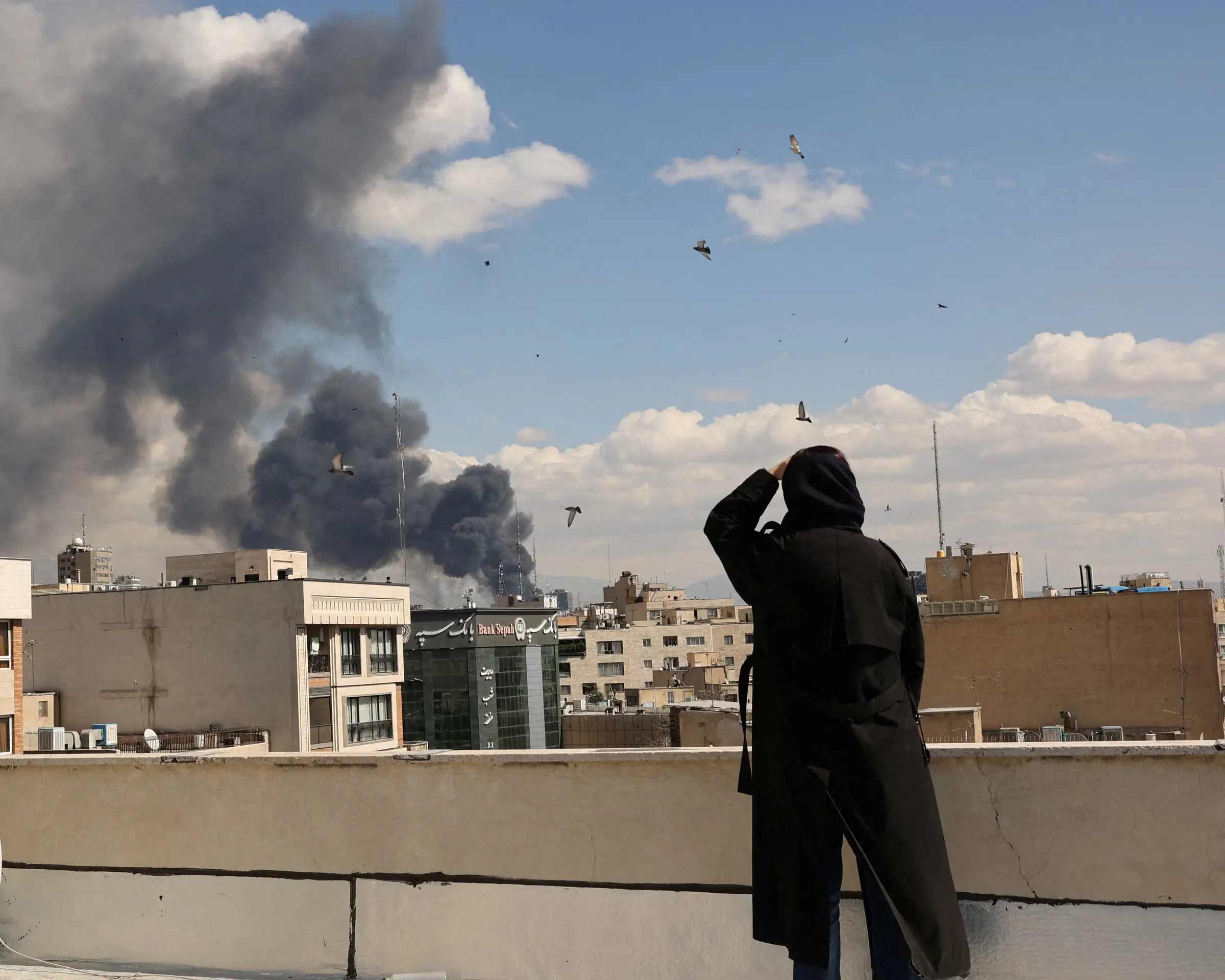 İsrail ve ABD'nin İran'a düzenlediği hava saldırılarının ardından 8 Mart'ta Tahran'daki binaların üzerinden duman yükseliyor.