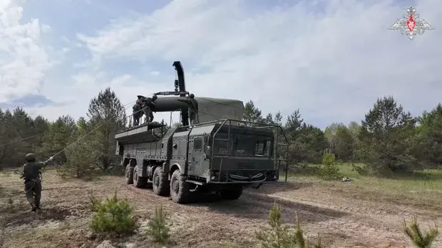 Rusya Savunma Bakanlığı tarafından 21 Mayıs 2026'da yayınlanan videodan alınan bir karede, Belarus'ta kimliği belirsiz bir yerde düzenlenen nükleer kuvvetler tatbikatı sırasında askerlerin Rus yapımı Iskander-M füze fırlatma rampasına bir füze yerleştirdiği görülüyor.