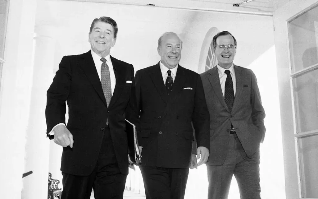 George Shultz (ortada), Sovyetler Birliği ile Cenevre'de iki gün süren silah görüşmelerinin ardından 9 Ocak 1985'te Washington'daki Beyaz Saray'a varışında dönemin Başkanı Ronald Reagan ve Başkan Yardımcısı George Bush ile birlikte yürüyor. (AP Fotoğrafı/Barry Thumma, Arşiv)